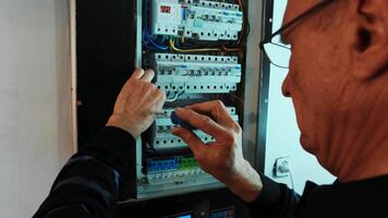 Electricians hands working on current electric in control panel. Electrician engineer work 2 video