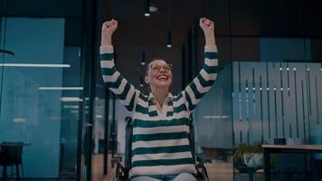 A joyful woman with disabilities in a wheelchair raises her arms in celebration in a modern startup office, an inclusive workplace, empowerment, success, accessibility, and positivity in a dynamic video