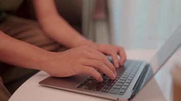 Close-up shot of a person hands typing on a laptop keyboard, showcasing focus and productivity in a casual, relaxed setting. Chat with modern technology chatbots video
