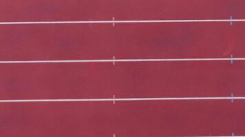 Aerial top down view of an empty running track, showcasing the pristine lanes, clear boundaries, and wide open space, emphasizing the stillness and solitude of the track, ideal for sports or fitness video