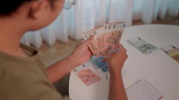 Counting currency a person hands carefully counting and sorting various banknotes, focusing on the detail of the currency and the careful handling. video