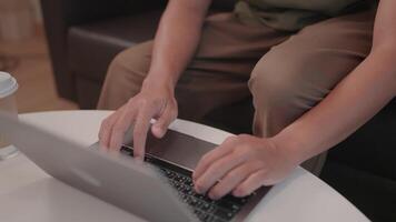 A focused man, absorbed in his work, types intently on a sleek laptop while seated in a contemporary, comfortable setting. Capturing his productivity and connection. Chat with modern technology video
