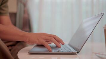 Laptop work from home .Close-up shot of hands typing on a laptop keyboard, suggesting remote work or online activity in a comfortable home setting. Chat with modern technology chatbots video