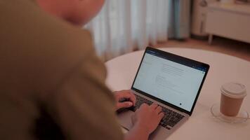 Working from home a person sits at a table typing on a laptop, enjoying the comforts of their home office. A cup of coffee sits nearby. . Chat with modern technology chatbots video