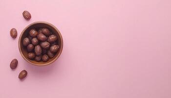 Dates fruit fresh organic on wooden bowl copy space pink background and some decoration photo