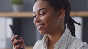 An African American woman teaches remotely, focused on her students during an online session. She creates an engaging environment for effective learning in her home office. video