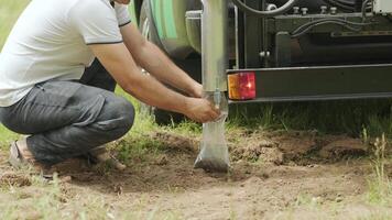 Man putting black soil into pack. Soil examination of agronomy. Geotechnical investigation. Collecting black soil on the field for examination and analysis. Special equipment for pickup video