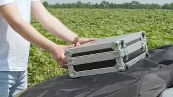 Laboratory assistant opens a case with laboratory equipment for plant analysis video