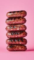 Grilled sausage chicken or beef stack on pink solid vertical background photo