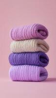 Sweaters stack with purple color, warm winter fashion style vertical background photo