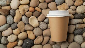 Brown paper cup disposable ecofriendly on pebble stones pattern soft color background photo