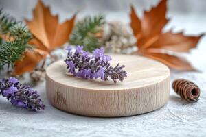 Lavender sprig on a wooden disc with autumn leaves and pine photo