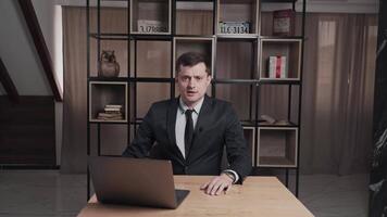 In a modern office, a suited businessman leads a meeting, highlighting teamwork and leadership skills video
