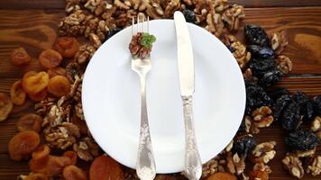 Clean empty plate and Nuts, dried apricots and prunes on a wooden table video