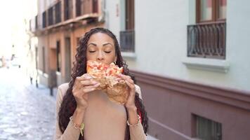 Savoring a Delicious Slice of Pizza While Wandering Through a Quaint City Street video