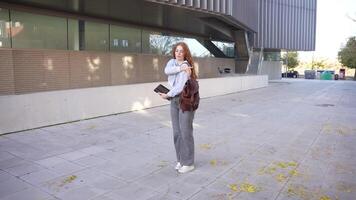 un estudiante es participación un libro mientras en un al aire libre Universidad ambiente, rodeado por naturaleza, video