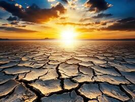 Stunning Sunset Over Cracked Earth in Arid Desert Landscape with Dramatic Sky and Clouds photo