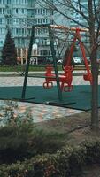 leeren Kinder- Spielplatz im ein Wohn Bereich. das Wind Felsen das Schaukeln sanft, hervorrufen ein Ruhe und nostalgisch Stimmung video