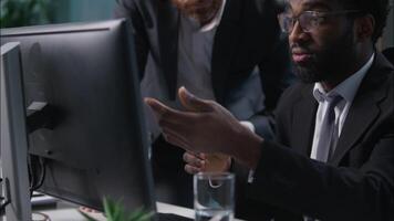 African American Caucasian men coworkers colleagues multiethnic males diversity guys businessmen business in office working computer digital tablet solve problem pc corporate teamwork talk discussing video