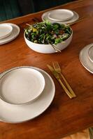 An appetizing vegetable salad, bursting with color and flavor, is presented on a stylishly decorated dining table, ready to be enjoyed. photo