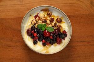 A fresh and nutritious yogurt bowl with berries and nuts, drizzled with honey is healthy breakfast photo