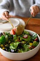 A colorful salad with crisp vegetables is elegantly served on a neatly arranged table, creating a fresh and inviting dining experience. photo