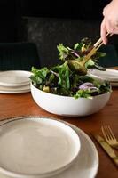 A refreshing salad with bright, fresh ingredients is carefully plated on a sophisticated table setting, perfect for a wholesome meal. photo