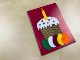 This charming card features felt applique of cake with candle and colorful eggs. Perfect for Easter greetings or birthday wishes, it adds personal touch to your celebrations photo