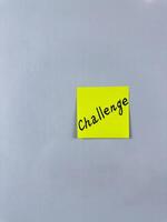 Sticky note with the word Challenge written on it, placed on white background. Ideal for illustrating themes of obstacles, goals, and motivation. Great for concept creation photo