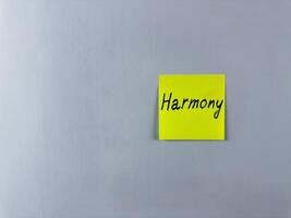 Sticky note with the word Harmony written on it, placed on white background. Ideal for illustrating harmony, balance, and unity in life and relationships. Perfect for concept creation photo
