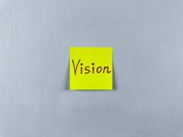 Sticky note with the word Vision written on it, pinned on white background. Photo symbolizes foresight, goals, and inspiration. Perfect for illustrating concepts of vision and future aspirations
