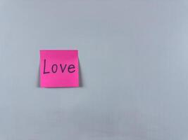 Sticky note with the word Love written on it, placed on a white background. Perfect for illustrating love, relationships, and emotional connection. Great for concept creation photo