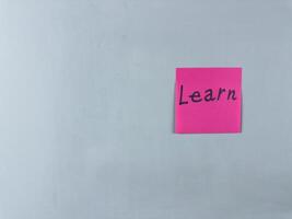 Sticky note with the word Learn written on it, placed on white background. Ideal for illustrating themes of education, knowledge, and personal growth. Great for concept creation photo