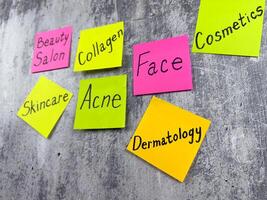 Nice simple concept about dermatology. Important words about skin care on sticky notes on white shabby background. Raising awareness about skin problems and importance of taking care of your body photo