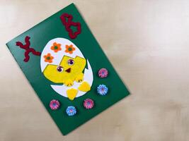 This delightful handmade Easter card features a cute chick emerging from an egg, adorned with colorful flowers. Perfect for sending warm wishes and spreading joy during the holiday season photo