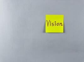 Sticky note with the word Vision written on it, placed on white background. Ideal for illustrating themes of foresight, goals, and inspiration. Great for concept creation photo