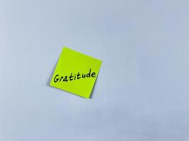 Sticky note with the word Gratitude, pinned on white background. Photo symbolizes thankfulness, appreciation, and positivity. Perfect for illustrating concepts of gratitude and gratefulness