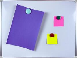 Vibrant paper notes in different colors attached to whiteboard with colorful magnets perfect for organizational and creative workspace themes photo