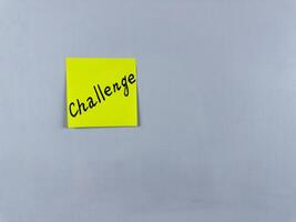Sticky note with Challenge written on it, affixed to white background. This image represents obstacles and goals, ideal for themes of taking on challenges and personal growth photo
