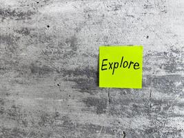 Vibrant green sticky note featuring the word Explore on a textured grey background, symbolizing curiosity, adventure, and the spirit of discovering new experiences photo