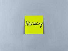 Sticky note with the word Harmony written on it, pinned on white background. Photo symbolizes peace, balance, and unity. Ideal for illustrating concepts of harmonious relationships and balanced life