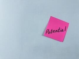 Sticky note with the word Potential written on it, placed on a white background. Ideal for illustrating themes of capability, growth, and opportunity. Great for concept creation photo