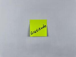 Sticky note with Gratitude written on it, affixed to white background. This image represents thankfulness and appreciation, ideal for themes of gratitude and positivity photo