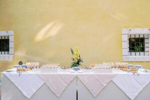 Buffet with small snacks and sandwiches stands against the wall of the building photo