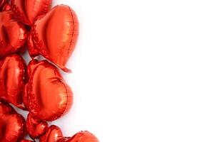 Set of red heart-shaped balloons on a white background. Place for layout. Balloons form a frame, located on the left on a white background. Foil-coated bright balloons, from large to small photo