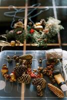 Fir cones, balls, threads and scissors for making a New Year wreath lie on the table photo