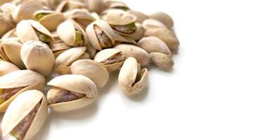 pistachio nuts on white background with copy space. Nuts rich in vitamins and microelements are ready to eat. Vegetarian food photo