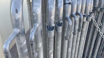 Metal barricades lined up against a wall in the bright sunlight on a warm afternoon in an urban setting photo