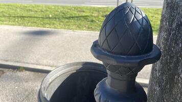 Decorative street trash can design adds charm to urban landscape in sunny afternoon photo
