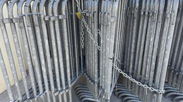 Metal barriers securely chained together on a sunny day in an outdoor setting, symbolizing order and organization photo